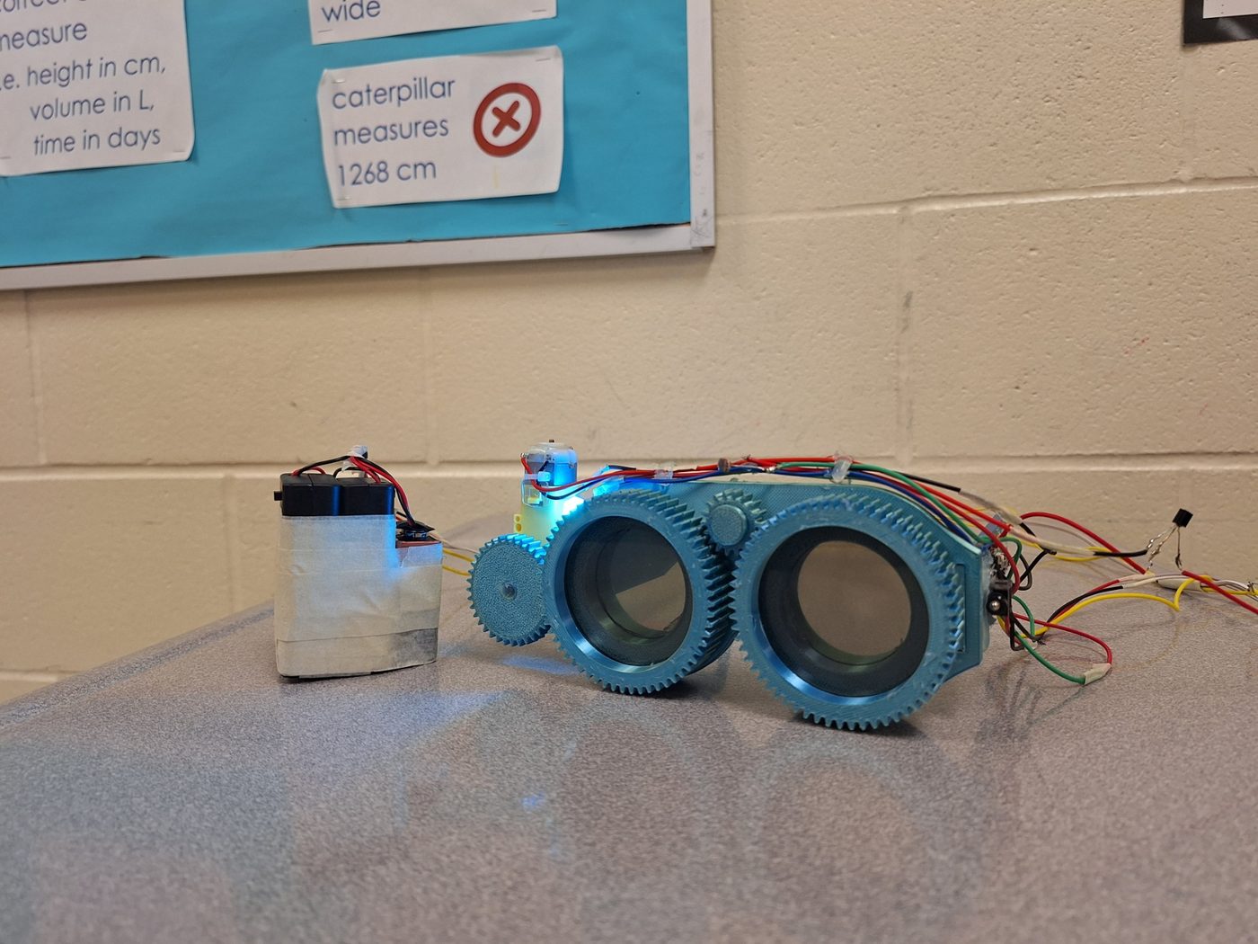 The StrobeShield prototype: 3D-printed geared glasses wired to a Raspberry Pi Pico